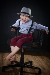 A styled young gentleman sitting and laughing on a chair