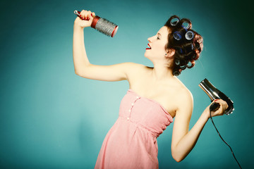 sexy girl in curlers with hairdryer styling hair © Voyagerix