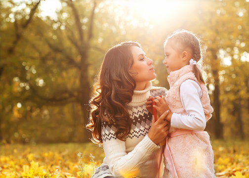 Mom And Daughter Having Fun In Autumn Park.