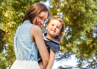 Naklejka premium Mother and daughter having fun in the autumn park