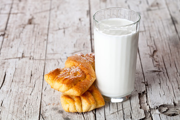 glass of milk and two fresh baked buns