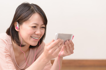 Fototapeta premium スマートフォンで音楽を聴く女性
