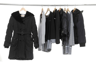 female clothing with set of black coat on hangers