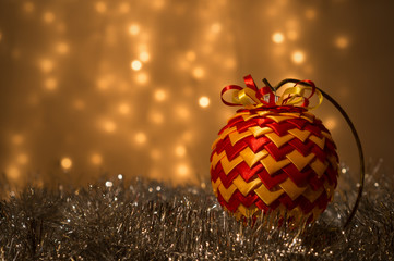 Dekoracja świąteczna  - bombka ze wstążek na tle lampek