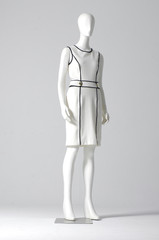 Mannequin dressed in white evening gown on gray