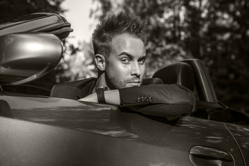 Elegant young handsome man and convertible car.
