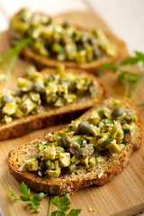 Bruschetta with green olives, anchovies, capers and parsley