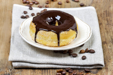 Delicious donut with chocolate on wooden table