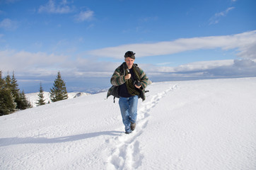 Fototapeta na wymiar Man running on snowy hill on sunny day