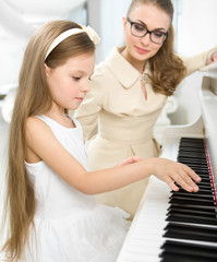 Master teaches little girl to play piano