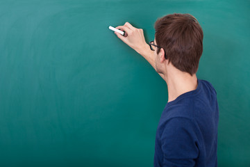 Male Student Writing On Chalkboard