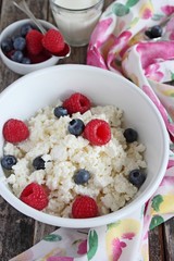 Portion of fresh cottage cheese with berries and milk