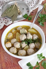 Fresh homemade soup with meat balls on a wooden background