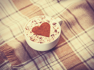 Cup with coffee and scarf.