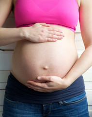 Female holding pregnant stomach