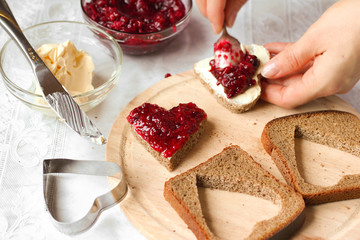 Woman cooking a sweet breakfast - bread with jam