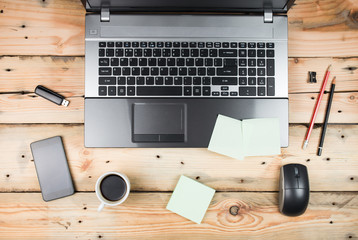 Workplace, laptop and notepad on wooden table