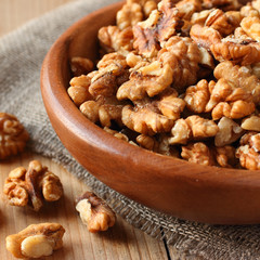 Shelled walnuts on wooden table with linen fabric