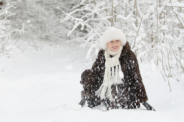 Fototapeta na wymiar Young woman playing with snow