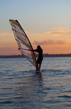 windsurfer on the calm water and red sky