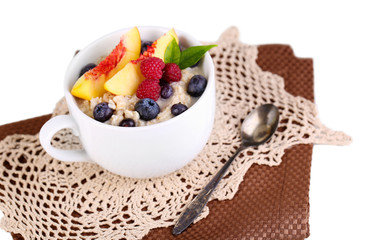 Oatmeal in cup with berries on napkins isolated on white