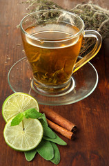 Transparent cup of green tea with lime and cinnamon