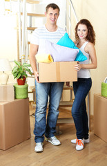 Fototapeta na wymiar Young couple with boxes in new home on staircase background
