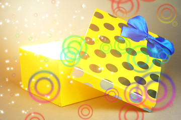 Gift box with bright light on it on grey background