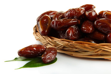 Dried dates on wicker plate isolated on white