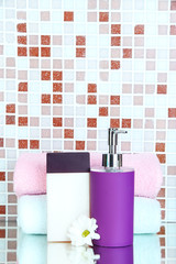 Cosmetics and bath accessories on mosaic tiles background