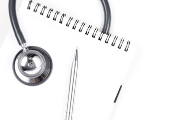 Stethoscope and silver pen on meadical notebook