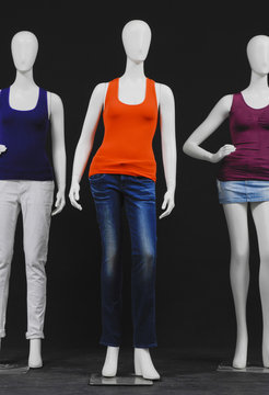 Three mannequin dressed in colorful shirt and jeans