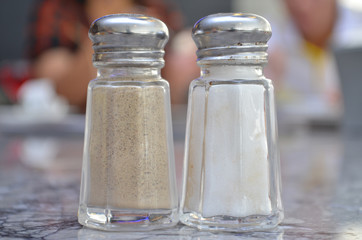 Glass salt and pepper shakers on table