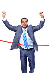 Happy businessman running through finishing line