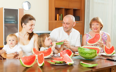 happy three generations family eating  melon
