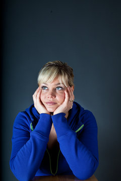 Cute blond girl with head in hands