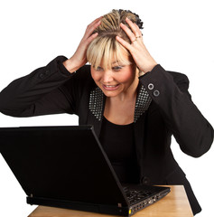 Studio portrait of a cute and desperate blond girl with a comput