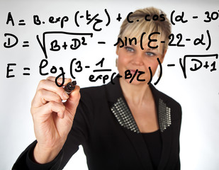 Studio portrait of a cute blond girl writing on a transparent wa