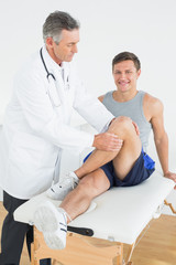Obraz premium Portrait of a smiling young man getting his leg examined