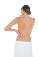 Rear view of a topless fit woman with shoulder pain