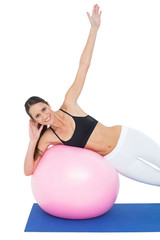 Fototapeta premium Portrait of a fit woman stretching on fitness ball