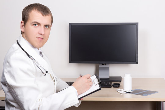 young male doctor working in modern office