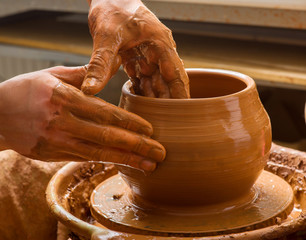 hands of a potter, creating an earthen jar on the circle