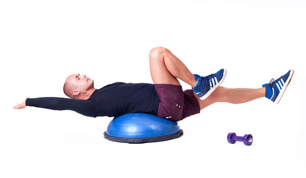 Sport man exercise with a pilates ball and dumbbells