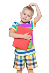 Pensive boy in striped shirt with books