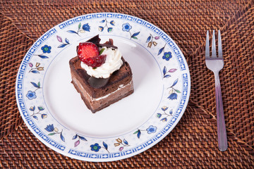Chocolate cake with fork and strawberry