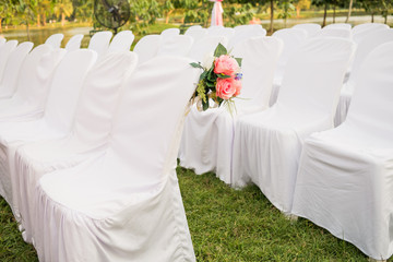 Empty white chairs in outdoor wedding