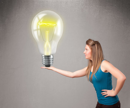 Beautiful lady holding realistic 3d light bulb