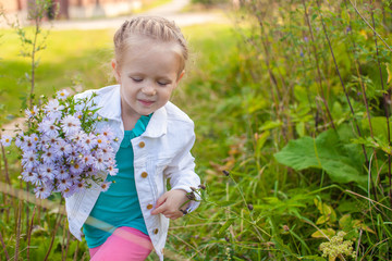 Little cute girl walking with a bouquet of flowers