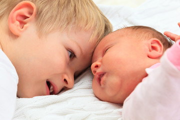 little boy playing with newborn sister